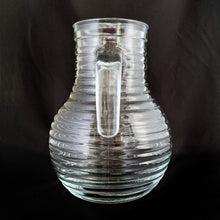 Load image into Gallery viewer, This vintage ribbed or beehive open handle pressed glass pitcher is perfect for water, lemonade, ice tea or the bevvy of your choosing. Made in Italy, circa 1960s.  In excellent condition, free from chips/cracks. Marked &quot;Italy&quot;  Measures 5 1/2 x 8 1/8 inches  Capacity 68 ounces   
