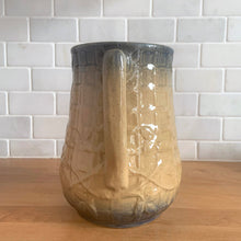 Load image into Gallery viewer, Vintage art deco gloss beige blue fade ceramic yellow ware pitcher featuring climbing roses on a trellis pattern. Crafted by McCoy Pottery, USA, 1920s. A beautiful piece to add to your art pottery collection!

In excellent condition, no chips/cracks/repairs, age-related crazing. Typical manufacturing glaze pops. Unmarked.

Measures 5 1/4 x 7 7/8 inches
