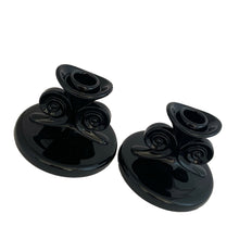 Load image into Gallery viewer, Hard-to-find pair of vintage black amethyst glass single lite candle holders, pattern 2395, featuring figural scrolls. Crafted by Fostoria Glass, USA, 1929 - 1939. These are perfect for long or short taper candles and will make a spooktacular accent for your Halloween decor or elegant tableware display!

In excellent condition, no chips.

Measures 4 1/2 x 3 1/4 inches
