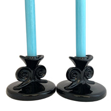 Load image into Gallery viewer, Hard-to-find pair of vintage black amethyst glass single lite candle holders, pattern 2395, featuring figural scrolls. Crafted by Fostoria Glass, USA, 1929 - 1939. These are perfect for long or short taper candles and will make a spooktacular accent for your Halloween decor or elegant tableware display!

In excellent condition, no chips.

Measures 4 1/2 x 3 1/4 inches
