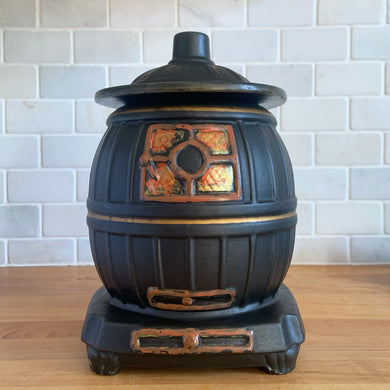 This vintage figural ceramic black pot belly stove cookie jar was crafted by McCoy Pottery in the 1960s. It's a must-have for any McCoy collector looking to add charm to their vintage cottage or farmhouse kitchen decor. This cookie jar is a perfect example of McCoy's expertise in creating high-quality and timeless pieces.

In excellent condition, no chip/cracks/repairs. There are a few tiny spots of glaze misses/loss.

Measures 6 3/4 x 7 x 10 3/8 inches