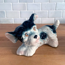 Load image into Gallery viewer, Vintage mid-century hand painted black and white playful Terrier puppy dog ceramic figurine. Crafted in Japan. Add some kitschy cuteness to your life!

In good vintage condition, very minor paint loss to the eyes, no chips/cracks/repairs, age-related crazing. Unmarked.

Measures 6 1/2 x 3 x 4 1/4 inches

