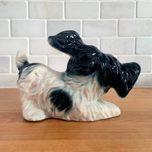 Load image into Gallery viewer, Vintage mid-century hand painted black and white playful Terrier puppy dog ceramic figurine. Crafted in Japan. Add some kitschy cuteness to your life!

In good vintage condition, very minor paint loss to the eyes, no chips/cracks/repairs, age-related crazing. Unmarked.

Measures 6 1/2 x 3 x 4 1/4 inches
