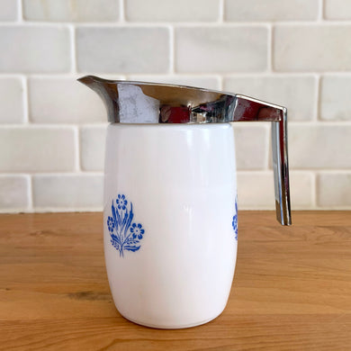 Vintage blue cornflowers white milk glass creamer pitcher with chrome plastic collar/handle. Crafted by Van Pak, Canada, 1970s. A piece of classic tableware!

In excellent condition, no chips.

Measures 2 3/4 x 5 inches