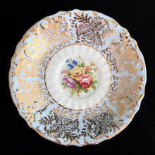 Load image into Gallery viewer, Vintage fine bone china blue teacup and saucer with colourful roses and gold gilt filigree and trim. Crafted by PARAGON, England. A lovely way to enjoy a cuppa tea!

In excellent condition, no chips, cracks or repairs. Single warrant stamp.

Measures 3 1/4 x 2 7/8 inches | Saucer measures 5 5/8 inches
