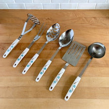 Load image into Gallery viewer, Overhead view of vintage 6-piece stainless steel kitchen utensil set with cream melamine handles, blue and green florals, Japan 1950s
