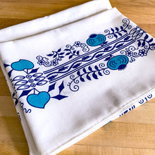 Load image into Gallery viewer, This exquisite Vintage Blue Onion Patterned White Linen Tablecloth is adorned with delicate blue teal florals, hearts, and onions, creating a charming and unique design. Crafted from high-quality linen, this tablecloth adds a touch of elegance to any dining experience. Perfect for casual and special occasions! In excellent condition, free from tears or stains. Measures 46 1/2 x 56 inches
