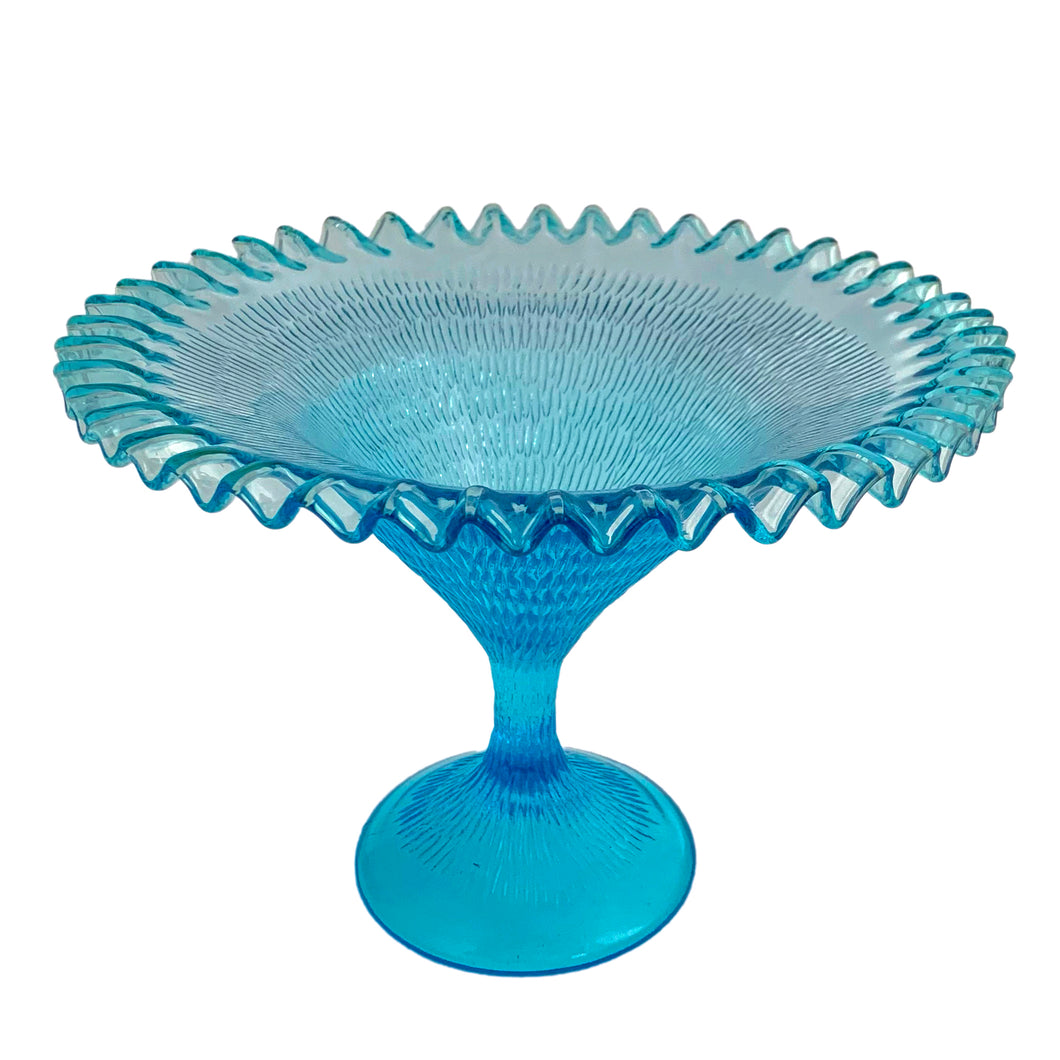 Exquisite blue glass pedestal compote featuring a textured exterior finish and crimped edge. Crafted by Zabkowice Glassworks, Poland, circa 1970s. Enhance your home decor with this stunning piece of art glass! In excellent condition, free from chips. Measures 11 x 8 inches