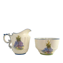 Load image into Gallery viewer, Vintage Bluebell Time bone china creamer and sugar featuring a delicately shaped vessels decorated with springtime woodland scene with bluebell flowers amongst groves of trees and trimmed in blue. Crafted by Aynsley, England, 1934 - 1950s.

In excellent condition, no chips/cracks/repairs. Maker&#39;s mark present with Bluebell Time and As supplied to H.M. the Queen.

Creamer measures 2 1/2 x 3 1/8 inches

Sugar measures 3 1/4 x 1 7/8 inches
