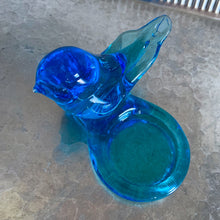 Load image into Gallery viewer, Lovely vintage hand blown art glass bluebird featuring a platform to hold a tea light or votive candle holder. Designed by artisan Leo Ward, his signature is on the bottom with the year 1987. Mr. Ward was the creator of Arkansas&#39; Bluebird of Happiness and owner of Terra Studios in Arkansas. He crafted these much beloved bluebirds until his death at 89.  In excellent condition, free from chips or cracks. Measures 4 x 3 3/4 x 2 1/2 inches
