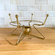 Load image into Gallery viewer, Vintage mid-century modern brass metal warming stand #468 features an atomic design with a holder for a votive candle. This stand fits a 2 quart Fire-King casserole dish., or could be used to keep a hot beverage carafe warm.  In excellent used vintage condition.  Measures 8 1/8 x 5 inches
