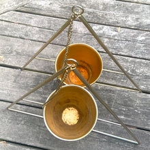 Load image into Gallery viewer, This is the real deal! Fabulous vintage triangular shaped brass metal wire plant hanger with fixed planter pot. They can be hung individually, in tandem or aligned for that added wow factor! Crafted in France, 1960s. A sweet way to add mid-century bohemian style to your home decor and the perfect gift for any plant lover!

In good vintage condition with original sticker. Age appropriate wear to the pot.

Hanging frame measures 20 3/4 x 33 inches, pot measures 6 1/8 x 5 1/8 inches
