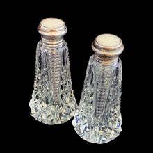 Load image into Gallery viewer, Enhance your tablescape with these sparkling vintage brilliant fine cut crystal tower-shaped salt and peppers shakers topped with sterling silver lids inlaid with mother-of-pearl....stunning!

The crystal is in excellent condition, no chips. The sterling silver lids show age related wear. Marked Sterling 925 with hallmark.

Measures 2 x 4 1/2 inches
