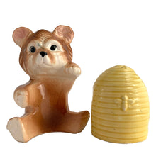 Load image into Gallery viewer, Vintage brown bear hugging a beehive ceramic salt and pepper shakers with plastic stoppers. Japan, 1970s. Add these adorable kitschy shakers to your collection!

In excellent condition, no chips/cracks/repairs. Marked Japan.

Bear measures 3 1/4 x 2 1/2 x 4 5/8 inches

Beehive measures 2 1/4 x 2 7/8 inches

