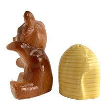 Load image into Gallery viewer, Vintage brown bear hugging a beehive ceramic salt and pepper shakers with plastic stoppers. Japan, 1970s. Add these adorable kitschy shakers to your collection!

In excellent condition, no chips/cracks/repairs. Marked Japan.

Bear measures 3 1/4 x 2 1/2 x 4 5/8 inches

Beehive measures 2 1/4 x 2 7/8 inches
