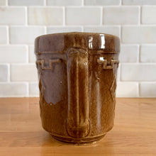 Load image into Gallery viewer, Vintage glossy caramel brown stoneware pitcher featuring a castle turret with diamonds detail. Crafted by Monmouth Western Stoneware, USA, 1920s. Add this utilitarian piece to your farmhouse decor or art pottery collection!

In excellent condition, no chips/cracks/repairs, age-related crazing. Unmarked.

Measures 4 1/2 x 5 inches
