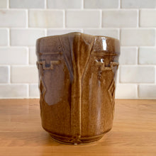 Load image into Gallery viewer, Vintage glossy caramel brown stoneware pitcher featuring a castle turret with diamonds detail. Crafted by Monmouth Western Stoneware, USA, 1920s. Add this utilitarian piece to your farmhouse decor or art pottery collection!

In excellent condition, no chips/cracks/repairs, age-related crazing. Unmarked.

Measures 4 1/2 x 5 inches
