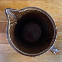 Load image into Gallery viewer, Vintage glossy caramel brown stoneware pitcher featuring a castle turret with diamonds detail. Crafted by Monmouth Western Stoneware, USA, 1920s. Add this utilitarian piece to your farmhouse decor or art pottery collection!

In excellent condition, no chips/cracks/repairs, age-related crazing. Unmarked.

Measures 4 1/2 x 5 inches
