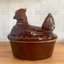 Load image into Gallery viewer, Vintage brown drip glaze hen-on-nest oven-proof casserole dish. Crafted by Hull Pottery, USA, 1960s. What a fabulous way to prepare and serve your favourite casserole!

In excellent condition, no chips/cracks/repairs. Maker's marks.

Measures 10 x 7 1/2 x 9 3/4 inches
