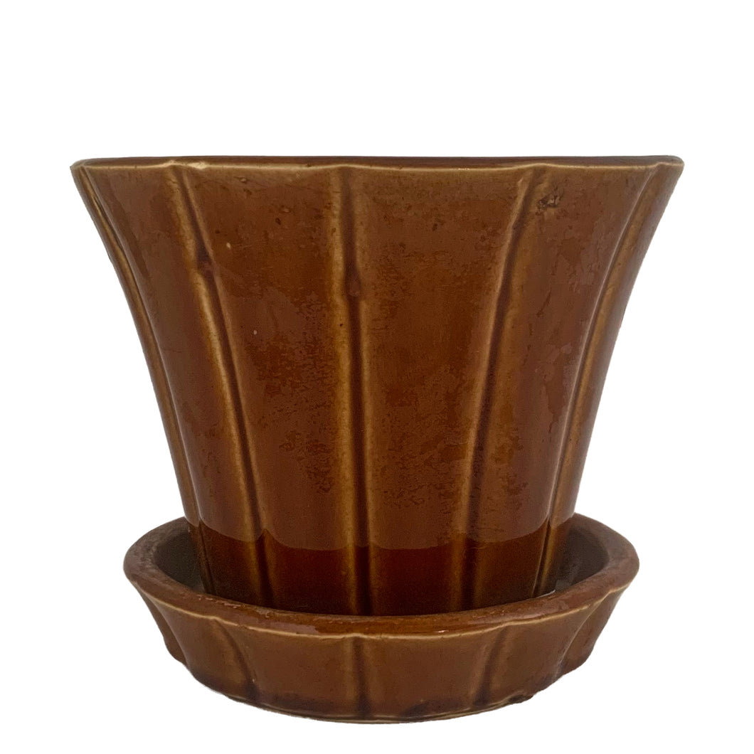 Striking vintage gloss brown Series 116 ribbed planter pot with attached saucer. Crafted by McCoy Pottery, 1940s. This rare planter is must for any McCoy art pottery collector!

In good vintage condition, flea bite at rim, hard water residue. Maker's mark on the bottom.

Measures 6 x 5 inches