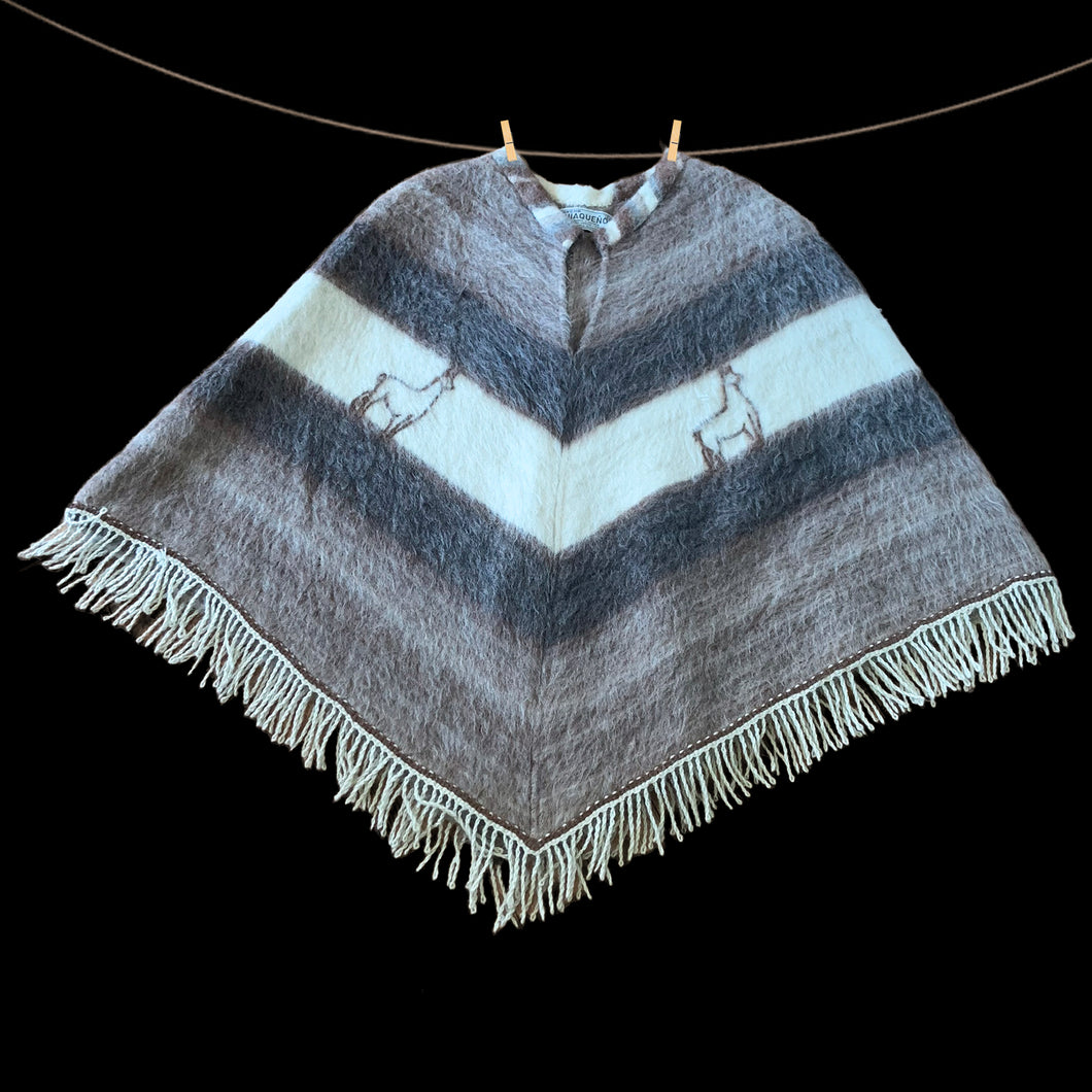 Charming vintage Boho-inspired split v-neck poncho, boasting a beautiful striped pattern in brown, mocha, and cream. The addition of a playful llama motif and fringed hem adds a touch of whimsy. This poncho is the perfect blend of style and comfort crafted from 50% llama/alpaca and 50% Merino wool, crafted by Poncho Quiaqueño, Argentina. A fabulous fashion statement to stay warm on those chilly days.

In excellent vintage condition.

Measures 20 inches across the shoulders and 42 inches across the bottom.
