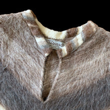 Load image into Gallery viewer, Charming vintage Boho-inspired split v-neck poncho, boasting a beautiful striped pattern in brown, mocha, and cream. The addition of a playful llama motif and fringed hem adds a touch of whimsy. This poncho is the perfect blend of style and comfort crafted from 50% llama/alpaca and 50% Merino wool, crafted by Poncho Quiaqueño, Argentina. A fabulous fashion statement to stay warm on those chilly days.

In excellent vintage condition.

Measures 20 inches across the shoulders and 42 inches across the bottom.
