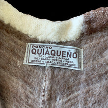 Load image into Gallery viewer, Charming vintage Boho-inspired split v-neck poncho, boasting a beautiful striped pattern in brown, mocha, and cream. The addition of a playful llama motif and fringed hem adds a touch of whimsy. This poncho is the perfect blend of style and comfort crafted from 50% llama/alpaca and 50% Merino wool, crafted by Poncho Quiaqueño, Argentina. A fabulous fashion statement to stay warm on those chilly days.

In excellent vintage condition.

Measures 20 inches across the shoulders and 42 inches across the bottom.
