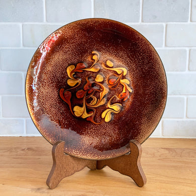 Vintage artisan made copper enamel bowl with a swirled design in orange and gold against a brown and copper ground. Signed by the artist, MG. An absolutely gorgeous piece of art that will enhance your home's decor. Use as a catchall or wall art.  In excellent condition.  Measures 7 3/8
