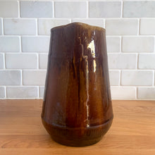 Load image into Gallery viewer, Vintage gloss brown stoneware pitcher with ribbed bands. Crafted by Medalta Stoneware, Canada, 1924. This utilitarian piece nicely complement any farmhouse or cottage kitchen!

In as found vintage condition, no chips/repairs, 3 hairline cracks, age-related wear to the exterior. Unmarked.

Measures 6 3/8 x 7 1/4 inches
