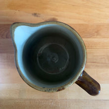 Load image into Gallery viewer, Vintage gloss brown stoneware pitcher with ribbed bands. Crafted by Medalta Stoneware, Canada, 1924. This utilitarian piece nicely complement any farmhouse or cottage kitchen!

In as found vintage condition, no chips/repairs, 3 hairline cracks, age-related wear to the exterior. Unmarked.

Measures 6 3/8 x 7 1/4 inches
