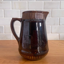 Load image into Gallery viewer, Vintage gloss brown stoneware pitcher with ribbed bands. Crafted by Medalta Stoneware, Canada, 1924. This utilitarian piece nicely complement any farmhouse or cottage kitchen!

In good vintage condition, no chips/cracks/repairs, age-related wear to the exterior. Unmarked.

Measures 5 x 5 1/2 inches
