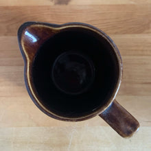 Load image into Gallery viewer, Vintage gloss brown stoneware pitcher with ribbed bands. Crafted by Medalta Stoneware, Canada, 1924. This utilitarian piece nicely complement any farmhouse or cottage kitchen!

In good vintage condition, no chips/cracks/repairs, age-related wear to the exterior. Unmarked.

Measures 5 x 5 1/2 inches
