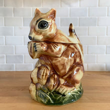 Load image into Gallery viewer, Rare vintage retro figural brown squirrel ceramic cookie jar. Crafted by McCoy Pottery, USA, 1950s. A good sized canister for a large batch of cookies. A great gift for the art pottery collector or animal lover. A whimsical piece that will look wonderful as part of your kitchen decor!

In vintage condition, no chips/cracks/repairs. There is age related crazing with staining at the bottom of the jar. Maker&#39;s mark.

Measures 8 x 6 x 10 1/2 inches
