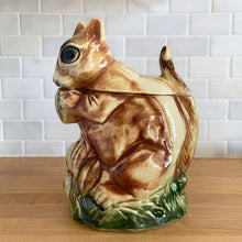Load image into Gallery viewer, Rare vintage retro figural brown squirrel ceramic cookie jar. Crafted by McCoy Pottery, USA, 1950s. A good sized canister for a large batch of cookies. A great gift for the art pottery collector or animal lover. A whimsical piece that will look wonderful as part of your kitchen decor!

In vintage condition, no chips/cracks/repairs. There is age related crazing with staining at the bottom of the jar. Maker&#39;s mark.

Measures 8 x 6 x 10 1/2 inches
