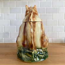 Load image into Gallery viewer, Rare vintage retro figural brown squirrel ceramic cookie jar. Crafted by McCoy Pottery, USA, 1950s. A good sized canister for a large batch of cookies. A great gift for the art pottery collector or animal lover. A whimsical piece that will look wonderful as part of your kitchen decor!

In vintage condition, no chips/cracks/repairs. There is age related crazing with staining at the bottom of the jar. Maker&#39;s mark.

Measures 8 x 6 x 10 1/2 inches
