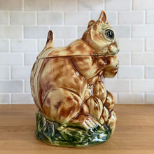 Load image into Gallery viewer, Rare vintage retro figural brown squirrel ceramic cookie jar. Crafted by McCoy Pottery, USA, 1950s. A good sized canister for a large batch of cookies. A great gift for the art pottery collector or animal lover. A whimsical piece that will look wonderful as part of your kitchen decor!

In vintage condition, no chips/cracks/repairs. There is age related crazing with staining at the bottom of the jar. Maker&#39;s mark.

Measures 8 x 6 x 10 1/2 inches
