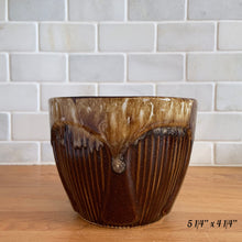 Load image into Gallery viewer, Front view of the 5-inch brown drip glaze jardiniere planter with vertical ribbing and tan glaze pooling at the rim
