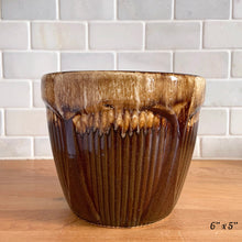 Load image into Gallery viewer, Side view of the 6-inch jardiniere planter showing the drip glaze cascading unevenly over the ribbed brown body
