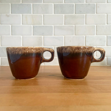 Pair of vintage glossy brown drip glaze mugs. Crafted by Hull Pottery, USA, 1960s. Enjoy any hot beverage in this fabulous retro oven-proof tableware!

In excellent condition, no chips/cracks/repairs. Maker's marks.

Measures 3 5/8 x 3 1/8 inches

Capacity 8 ounces