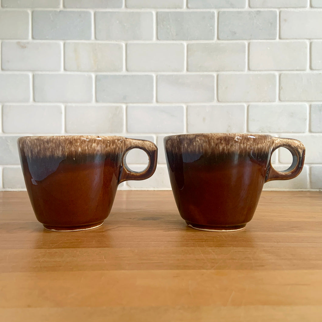 Pair of vintage glossy brown drip glaze mugs. Crafted by Hull Pottery, USA, 1960s. Enjoy any hot beverage in this fabulous retro oven-proof tableware!

In excellent condition, no chips/cracks/repairs. Maker's marks.

Measures 3 5/8 x 3 1/8 inches

Capacity 8 ounces
