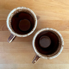 Load image into Gallery viewer, Pair of vintage glossy brown drip glaze mugs. Crafted by Hull Pottery, USA, 1960s. Enjoy any hot beverage in this fabulous retro oven-proof tableware!

In excellent condition, no chips/cracks/repairs. Maker&#39;s marks.

Measures 3 5/8 x 3 1/8 inches

Capacity 8 ounces
