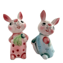 Load image into Gallery viewer, Vintage anthropomorphic bunny rabbit couple ceramic salt and pepper shakers wearing pink and blue pyjamas. Japan 1950s. Add these adorable and highly collectible kitschy shakers to your collection!

In excellent vintage condition, no chips/cracks/repairs. One has the cork stopper, the other is missing. Marked Japan.

Measures 1 1/2 x 1 1/2 x 3 5/8 inches
