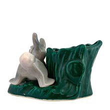 Load image into Gallery viewer, Adorable vintage ceramic planter featuring a white and gray bunny rabbit perched on a green tree stump. Crafted by Hollywood Ceramics California, USA, circa 1950s. Use this sweet planter to decorate your nursery, home or for your favourite succulent!  In excellent condition, free from chips.  Measures 5 1/4 x 3 3/4 x 3 1/4 inches
