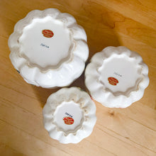 Load image into Gallery viewer, Rare set of three vintage mid-century white figural pumpkin/squash ceramic canisters. These three dimensional beauties are hand painted with colourful butterflies and flowers and each lid is topped with a floral finial. Imported to Canada by Enterprise Sales &amp; Distributors, from Japan, circa 1960s. Perfect for the kitchen kitsch collectible enthusiast!
