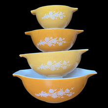 Load image into Gallery viewer, Set of four vintage Butterfly Gold 2 Cinderella nested mixing bowls. including the 441, 442, 443 and 444 sizes This classic was designed by Gregory Mirow and produced by PYREX, USA, 1979-1981. This version of the pattern features an asymmetrical flower and butterfly pattern in white alternating on golden-orange or golden-yellow ground. A must for the vintage kitchen and PYREX enthusiast!

Bowls are in excellent condition, shiny, no chips.
