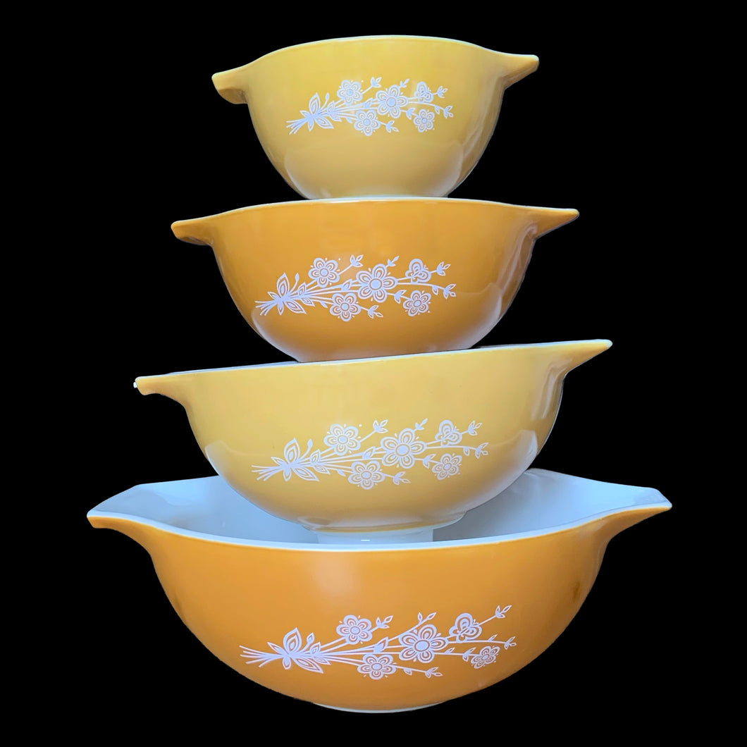 Set of four vintage Butterfly Gold 2 Cinderella nested mixing bowls. including the 441, 442, 443 and 444 sizes This classic was designed by Gregory Mirow and produced by PYREX, USA, 1979-1981. This version of the pattern features an asymmetrical flower and butterfly pattern in white alternating on golden-orange or golden-yellow ground. A must for the vintage kitchen and PYREX enthusiast!

Bowls are in excellent condition, shiny, no chips.