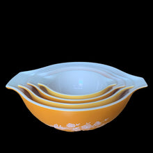 Load image into Gallery viewer, Set of four vintage Butterfly Gold 2 Cinderella nested mixing bowls. including the 441, 442, 443 and 444 sizes This classic was designed by Gregory Mirow and produced by PYREX, USA, 1979-1981. This version of the pattern features an asymmetrical flower and butterfly pattern in white alternating on golden-orange or golden-yellow ground. A must for the vintage kitchen and PYREX enthusiast!

Bowls are in excellent condition, shiny, no chips.

