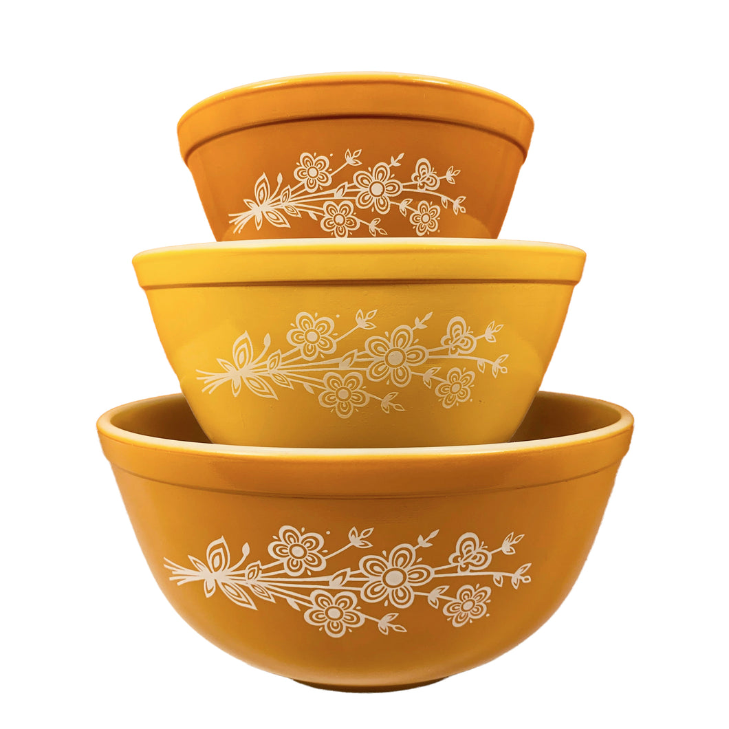Classic set of three vintage Butterfly Gold milk glass mixing bowls featuring a sweet pattern of flowers and butterflies on yellow and gold bowls. Designed by Gregory Mirow. Crafted by PYREX, USA, 1972 - 1979. These bowls are great for mixing, food storage and are oven and microwave safe. A timeless kitchen classic!

In excellent condition.

401 bowl measures 5 3/4 x 3 1/3 inches, 1 quart

402 bowl measures 7 1/4 x 3 3/4 inches, 2 quarts

403 bowl measures 8 3/4 x 4 inches, 3 quarts