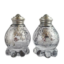 Load image into Gallery viewer, These vintage Imperial Candlewick clear glass salt and pepper shakers are beautifully decorated with silver overlay of orchid flowers. Crafted by Imperial Glass and Silver City, USA, circa 1950s. An lovely addition to your tableware! In excellent condition, free from chips or cracks. The silver overlay is stunning. Measures 1 7/8 x 3 inches

