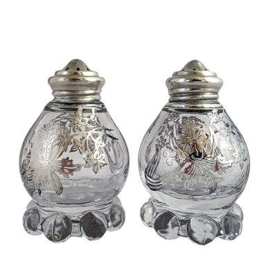 These vintage Imperial Candlewick clear glass salt and pepper shakers are beautifully decorated with silver overlay of orchid flowers. Crafted by Imperial Glass and Silver City, USA, circa 1950s. An lovely addition to your tableware! In excellent condition, free from chips or cracks. The silver overlay is stunning. Measures 1 7/8 x 3 inches